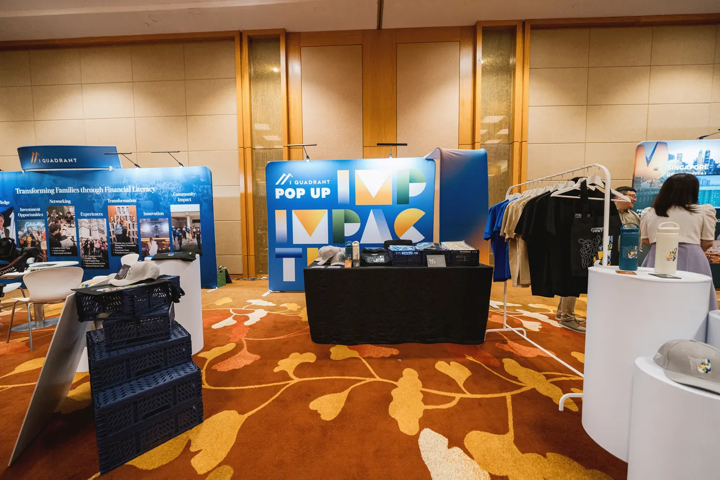 The summit merchandise booth, with the IMPACT backdrop and apparel on display